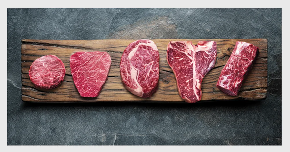A row of raw Wagyu cuts on a wooden board