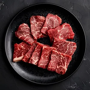 Cubed raw Wagyu beef on a black plate